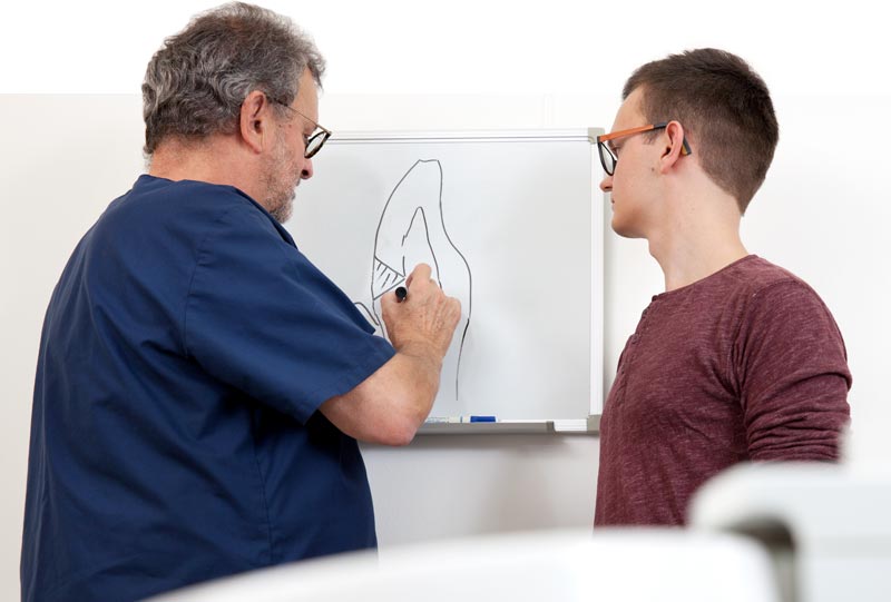 Foto von Dr. Maußner vor seinem Whiteboard